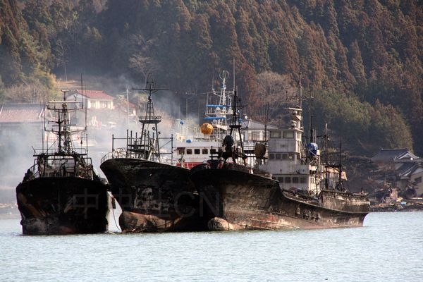 日本3月11日發生大地震引發海嘯，宮城縣氣仙沼港有漁船用油槽被海嘯捲倒，結果燃燒起火成一片火海。事經3天，船隻仍在冒煙。