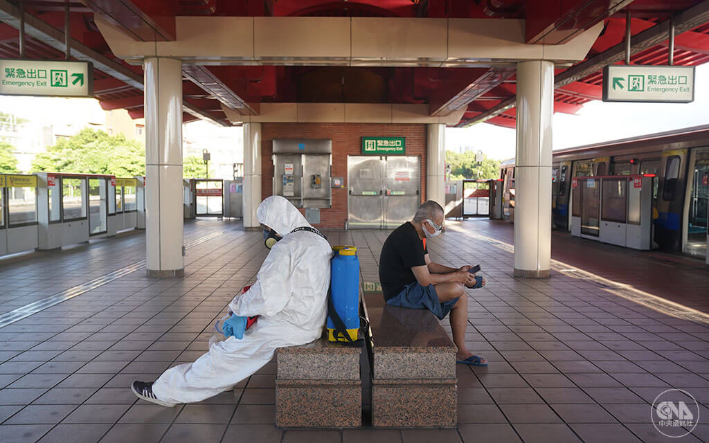 隨著疫情趨緩，國內7月13日起維持三級警戒，但部分管制鬆綁，提醒民眾迎微解封仍不可鬆懈。一名消毒人員（左）全副武裝噴消後，在北捷月台座椅稍作休息。