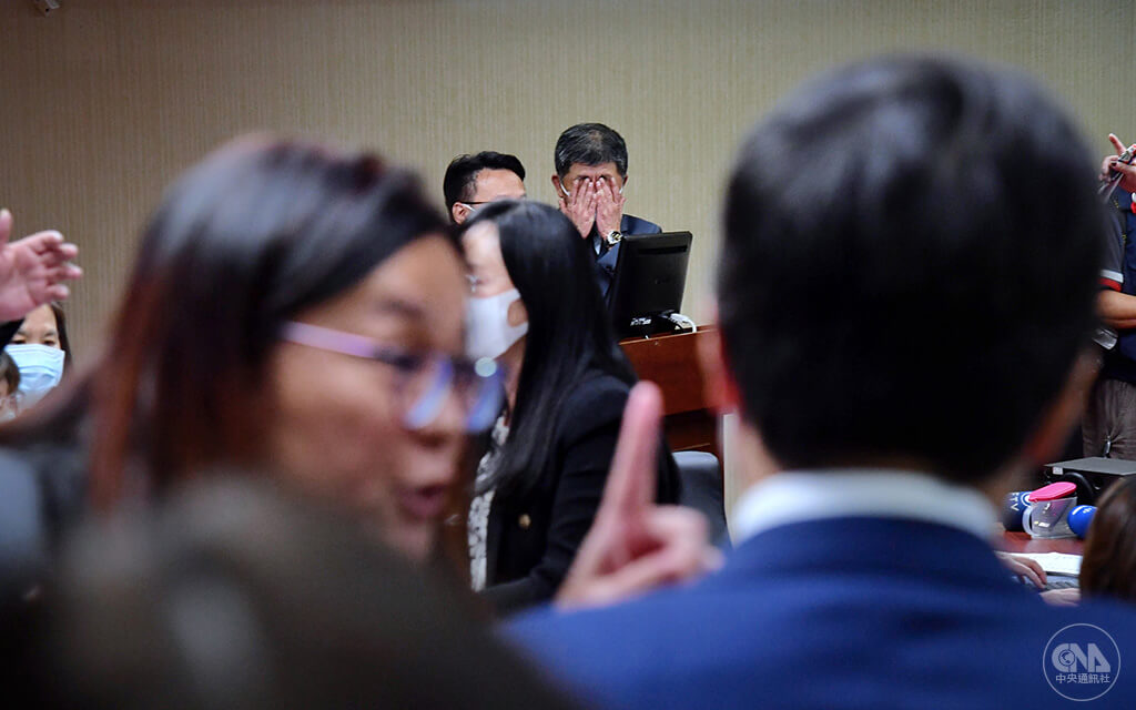COVID-19疫苗全球供不應求，到貨量不如預期，衛福部長陳時中（中）在立法院社福衛環委員會備詢，朝野立委為疫苗採購吵成一團。混亂中，備詢台上的陳時中雙手掩面。