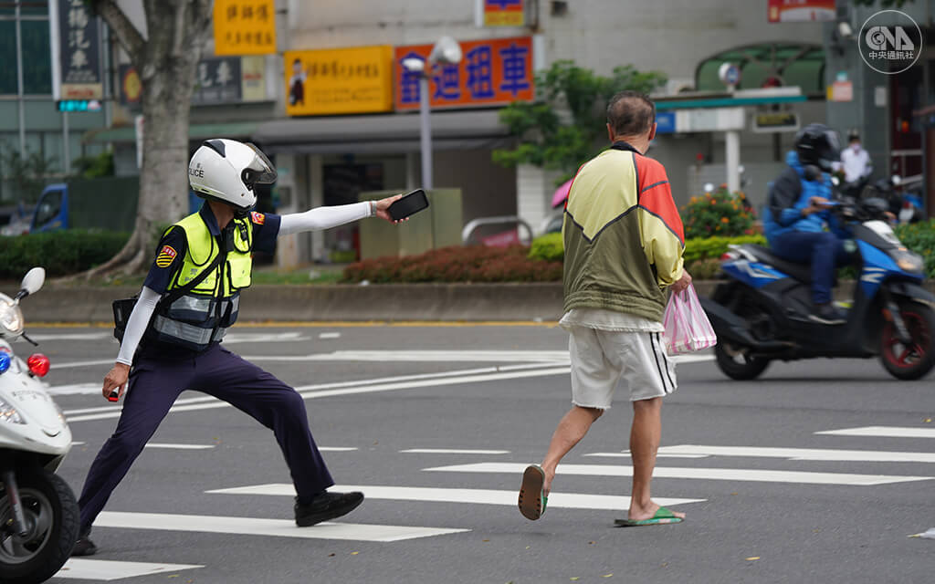 全國5月19日起升級為三級警戒。一名員警在北市街頭巡邏時，攔檢勸導沒戴口罩的民眾。